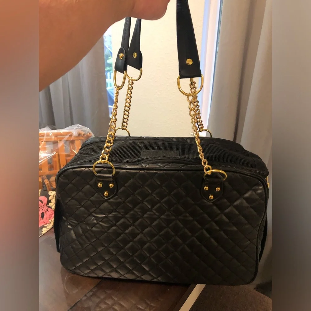 black quilted pet carrier tote with gold chain handles.